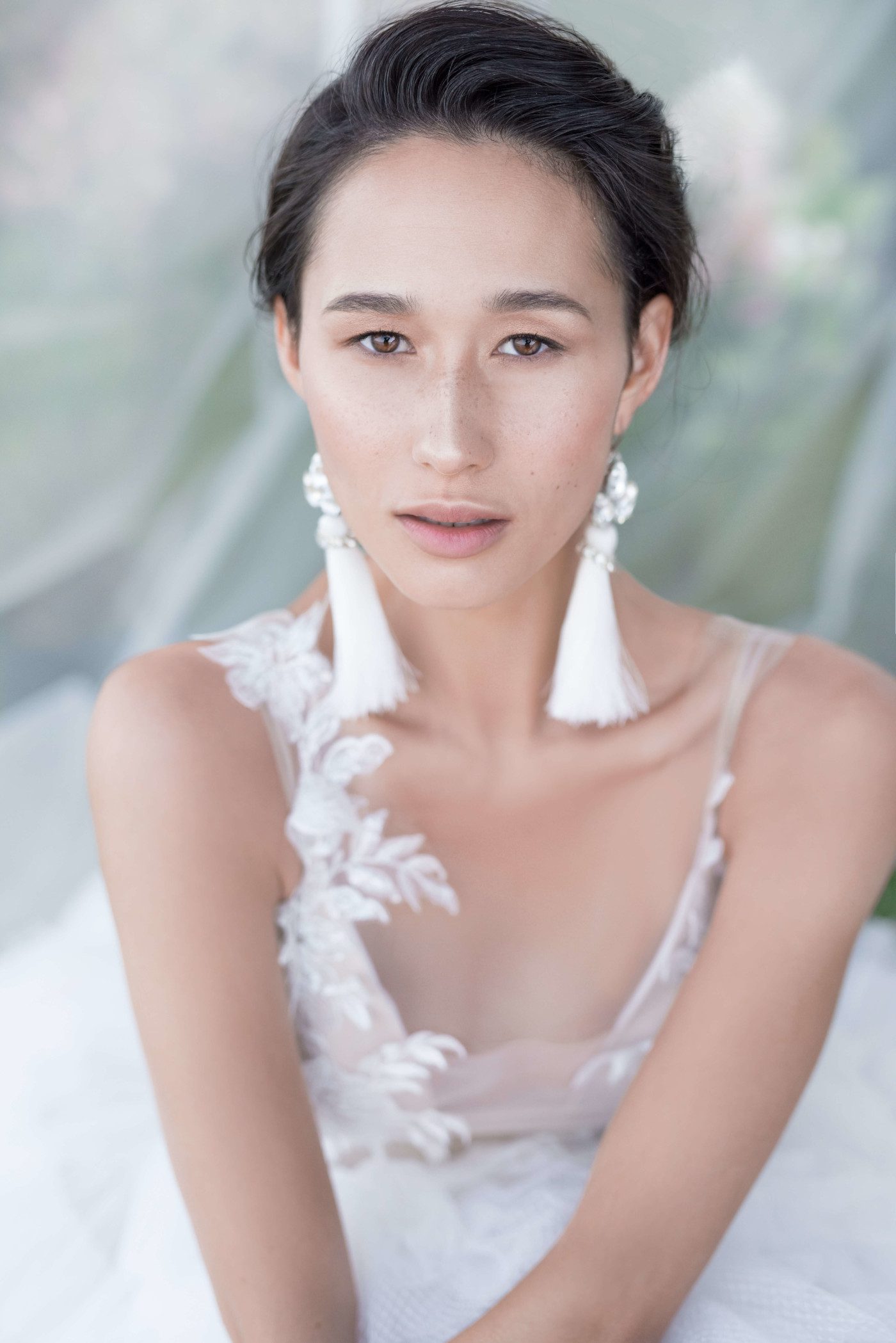 A bride wearing wedding dress with short skirt with horizontal flounces and lace bodice decorated with volume flowers by Rara Avis at Dell'Amore Bridal, Auckland, NZ. 2