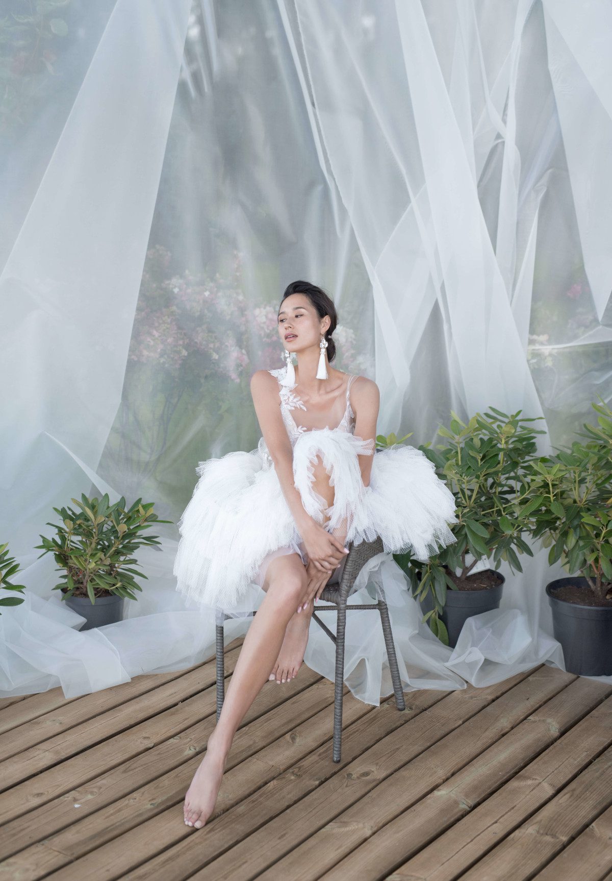 A bride wearing wedding dress with short skirt with horizontal flounces and lace bodice decorated with volume flowers by Rara Avis at Dell'Amore Bridal, Auckland, NZ. 1