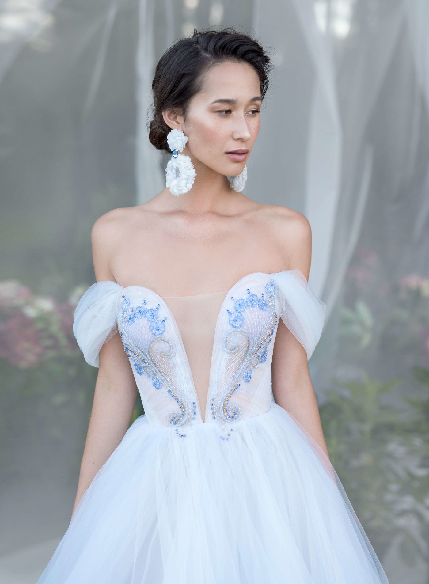 A bride wearing wedding dress with a long train, skirt decorated with lace elements and bodice decorated with beads and stones by Rara Avis at Dell'Amore Bridal, Auckland, NZ. 1