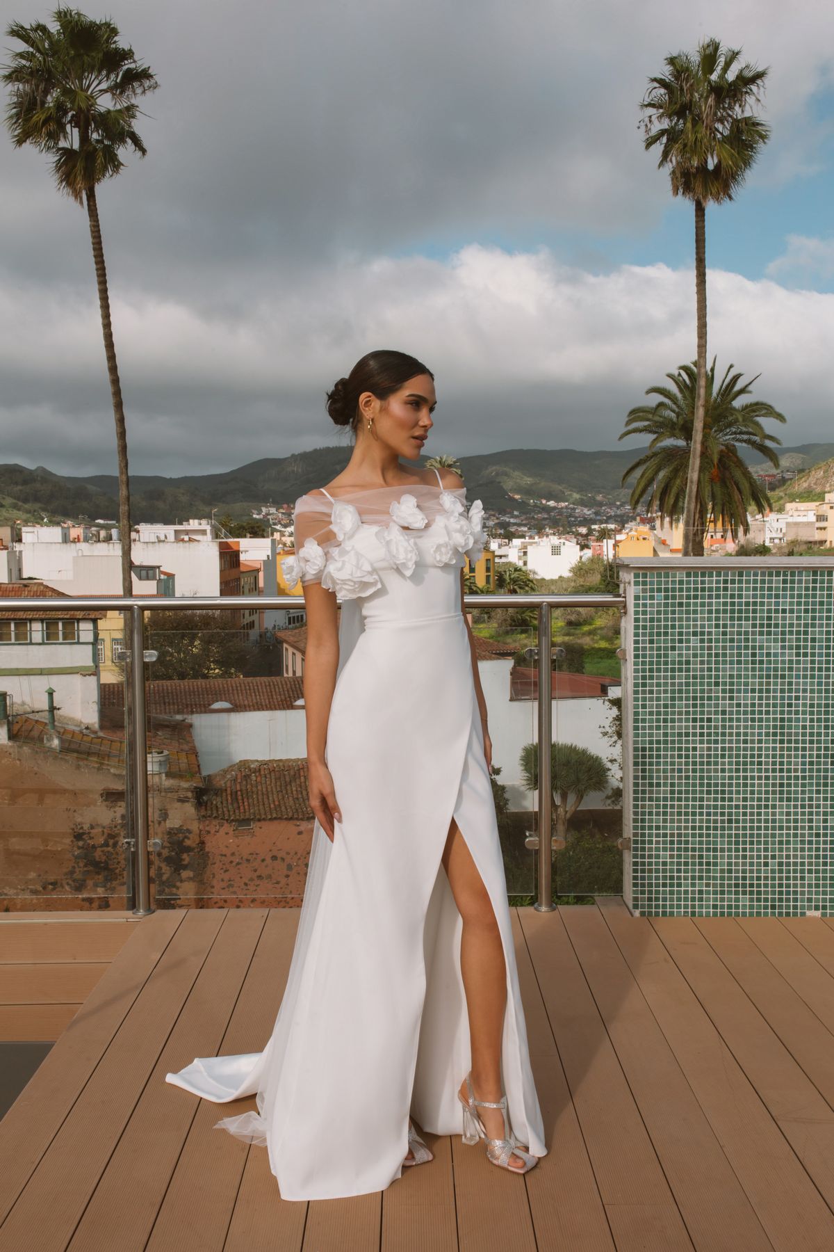 Simple fitted wedding dress Vidana with removable cape decorated with large 3-d flowers at Dell'Amore Bridal, NZ.6