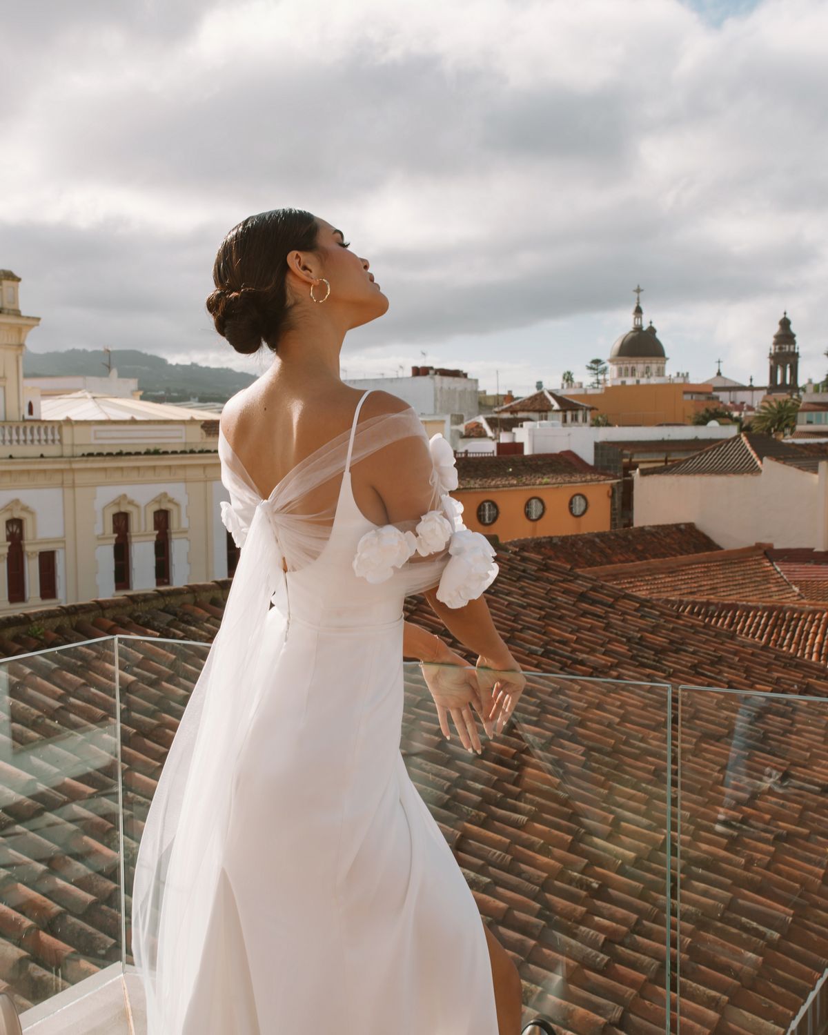 Simple fitted wedding dress Vidana with removable cape decorated with large 3-d flowers at Dell'Amore Bridal, NZ.5