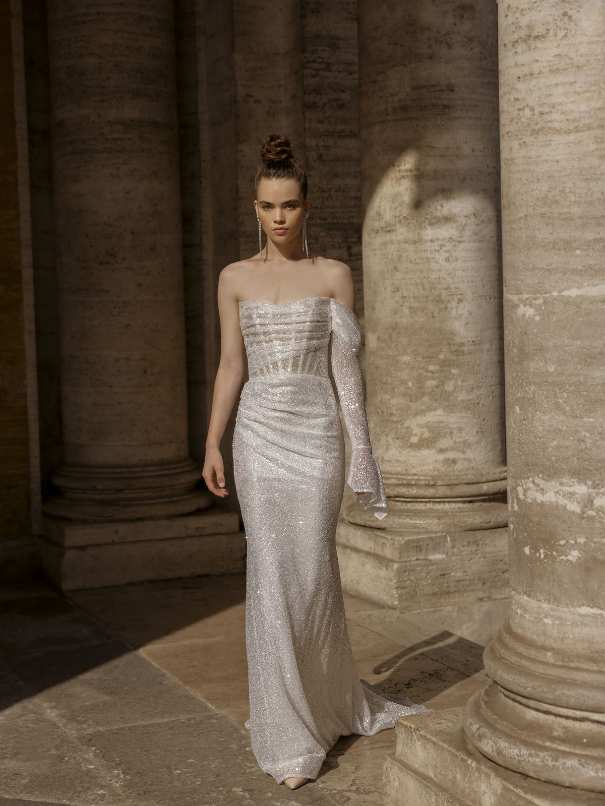 Fitted sparkling wedding dress Gracia with a wide draped shoulder strap and a detachable narrow sleeve by Rara Avis at Dell'Amore Bridal, Auckland. 11